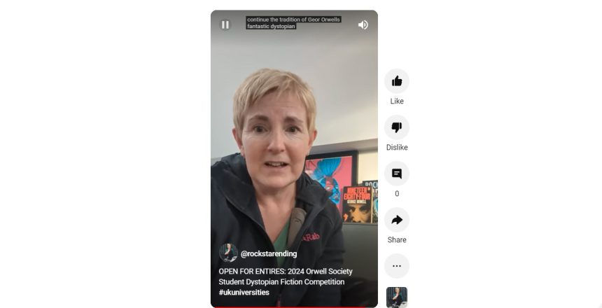 Woman with short hair talking with a copy of George Orwell's 1984 in the background